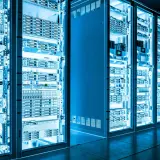 Reihen von Serverracks in einem Rechenzentrum, beleuchtet in blauem Licht. Die Geräte sind ordentlich angeordnet, bereit für NETCONF YANG-Konfigurationen.