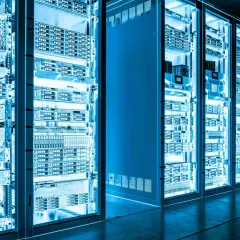 Reihen von Serverracks in einem Rechenzentrum, beleuchtet in blauem Licht. Die Geräte sind ordentlich angeordnet, bereit für NETCONF YANG-Konfigurationen.