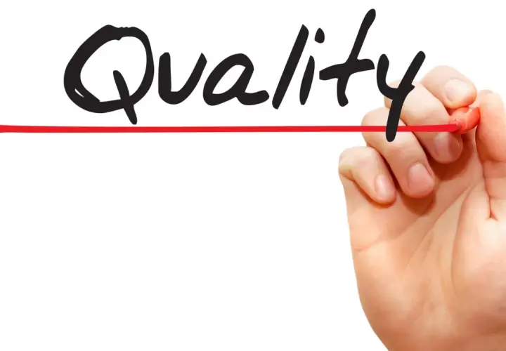 Hand schreibt "Quality" mit rotem Stift. Call monitoring für höchste Qualität.
