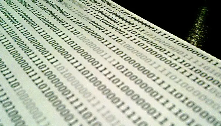 Binärcode auf Papier, der die Bedeutung von Jitter in der Datenübertragung veranschaulicht.