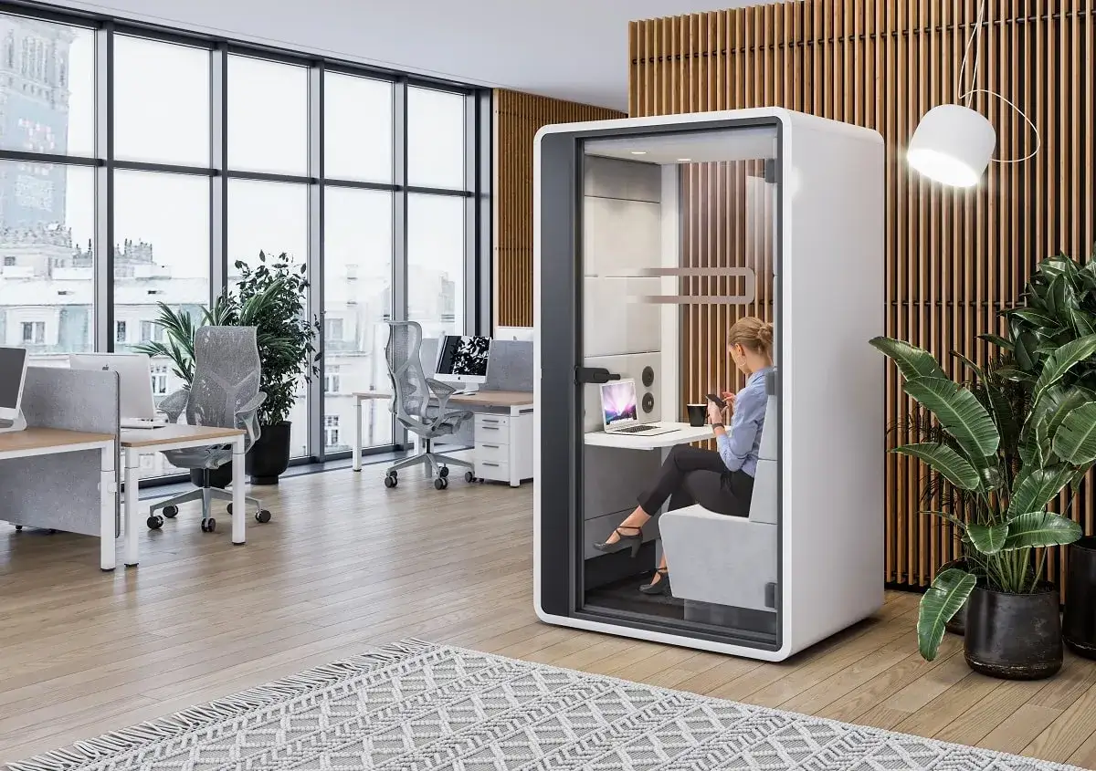 Frau in schallgedämmter Kabine für konzentriertes Arbeiten und Call Handling.